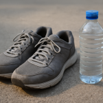 chaussures posées près d'une bouteille d'eau