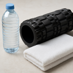 bouteille d'eau rouleau de massage et serviette posés